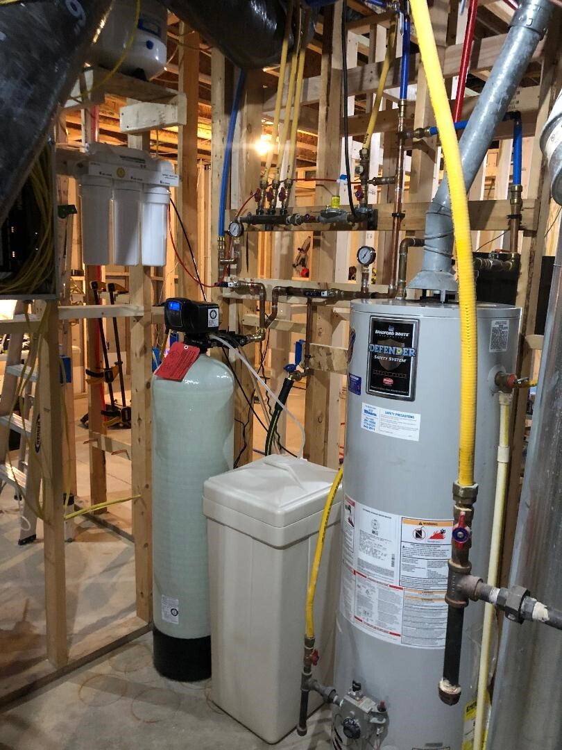 Beige and White Water Softener next to water heater